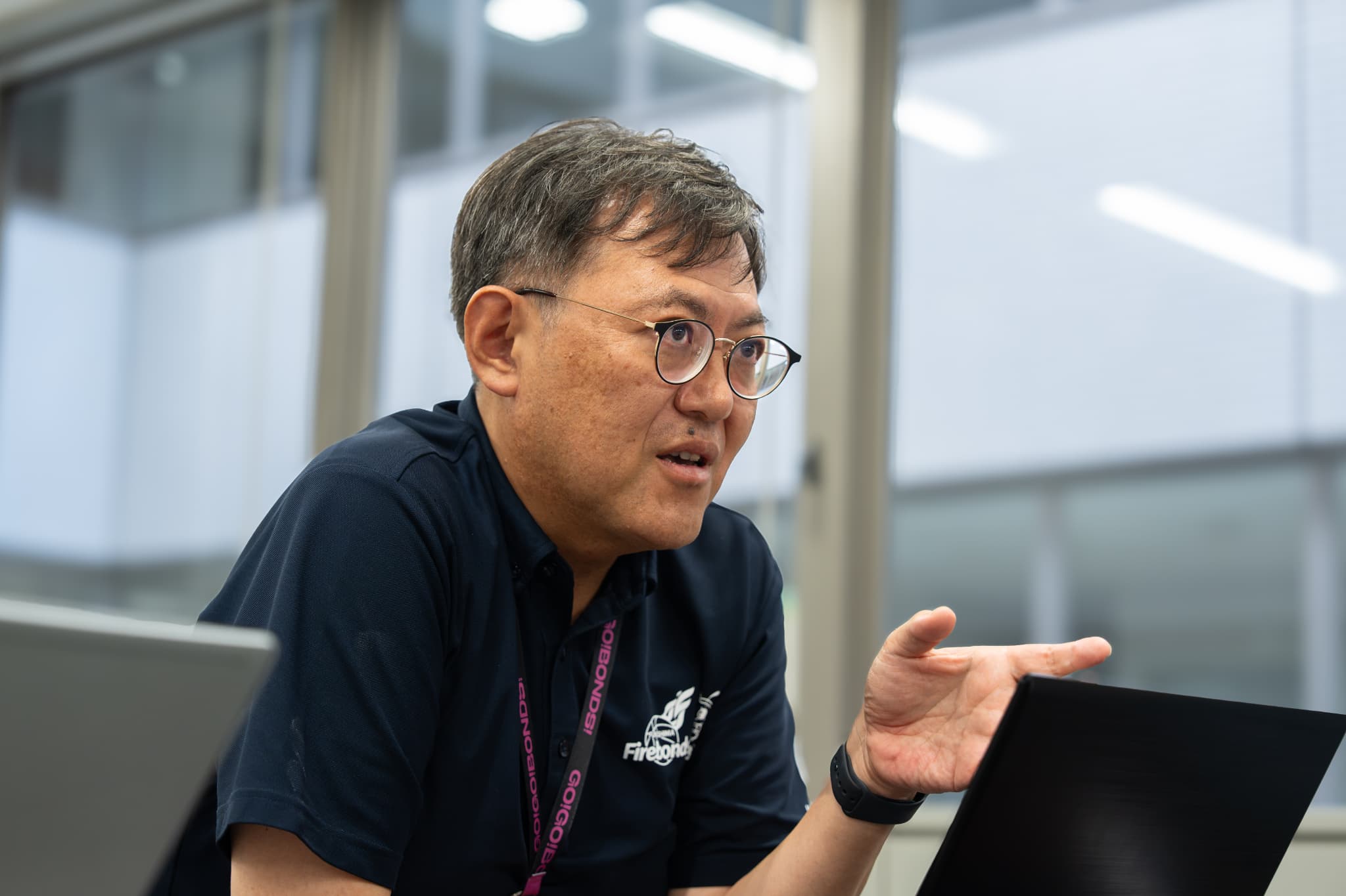 身ぶりを交えて話す郡山市スポーツ振興課の佐藤聡一