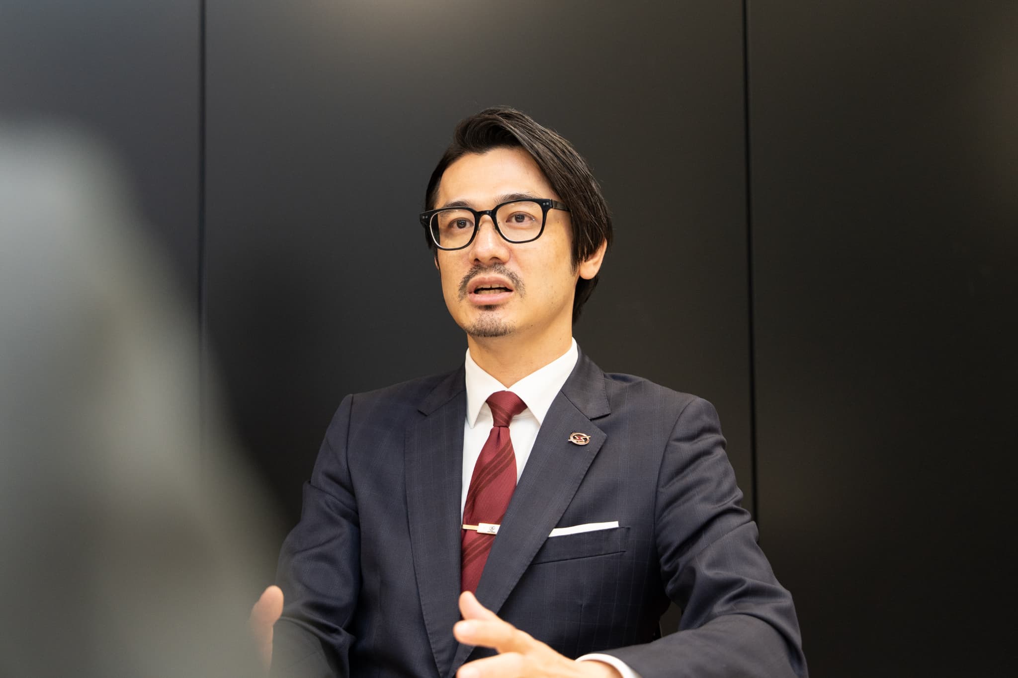 正面を向いて話す、川崎ブレイブサンダースの川崎渉社長